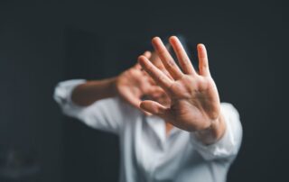 Female hand raised in fear.