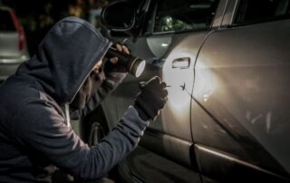 A man attempting car theft at night.