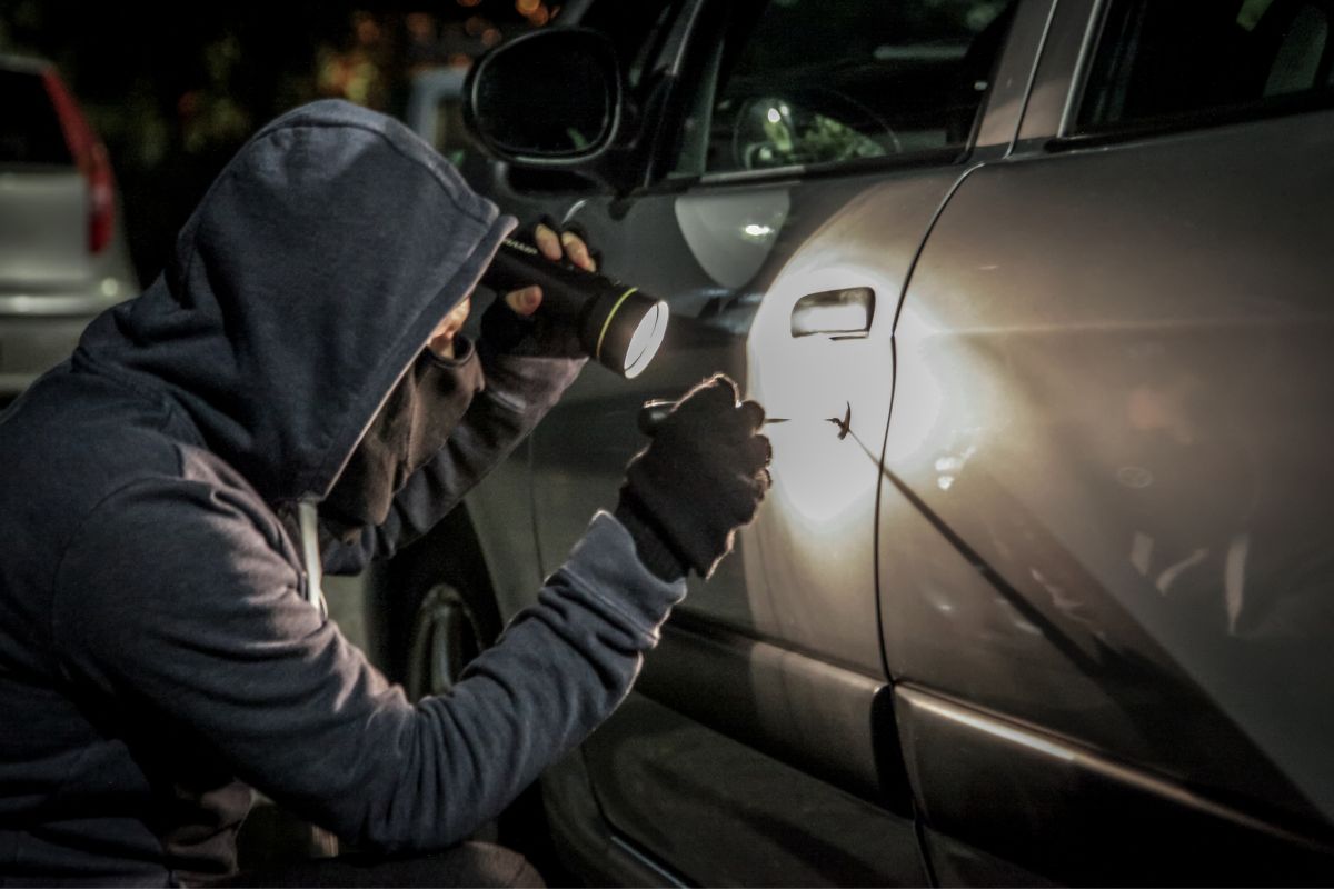 A man attempting car theft at night. A man attempting car theft at night.