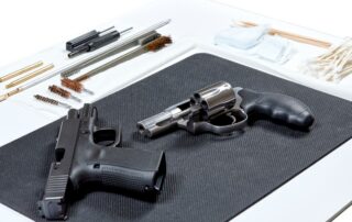 Two handguns placed on a black mat.