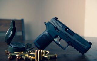 Handgun with bullets on a table.