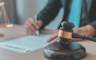 A lawyer signing legal documents at a desk.