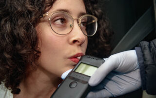 Woman breathing into a breathalyzer